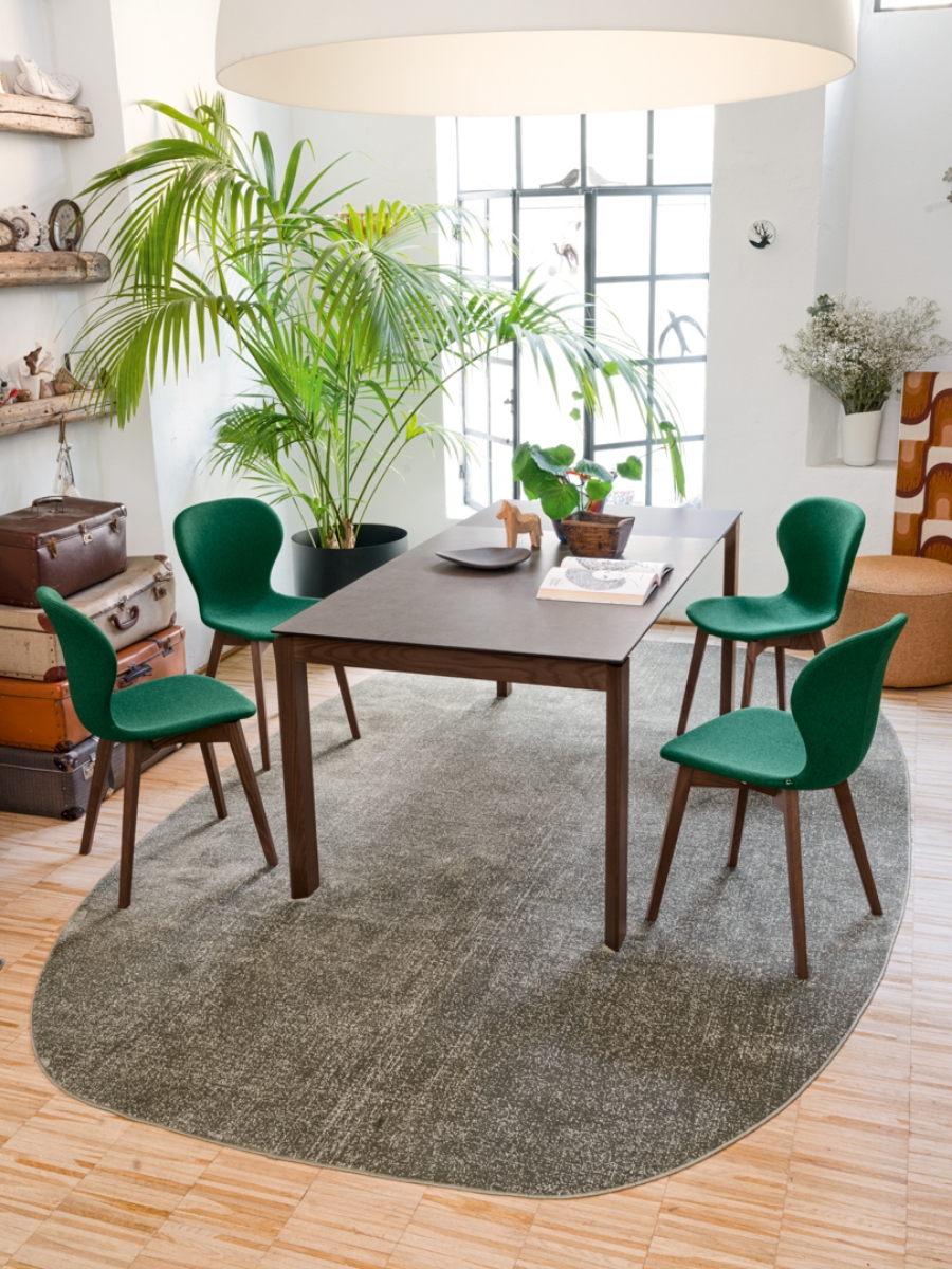 Τραπεζαρία με τέσσερις καρέκλες Ops της Connubia by Calligaris σε πράσινη ταπετσαρία γύρω από μοντέρνο τραπέζι