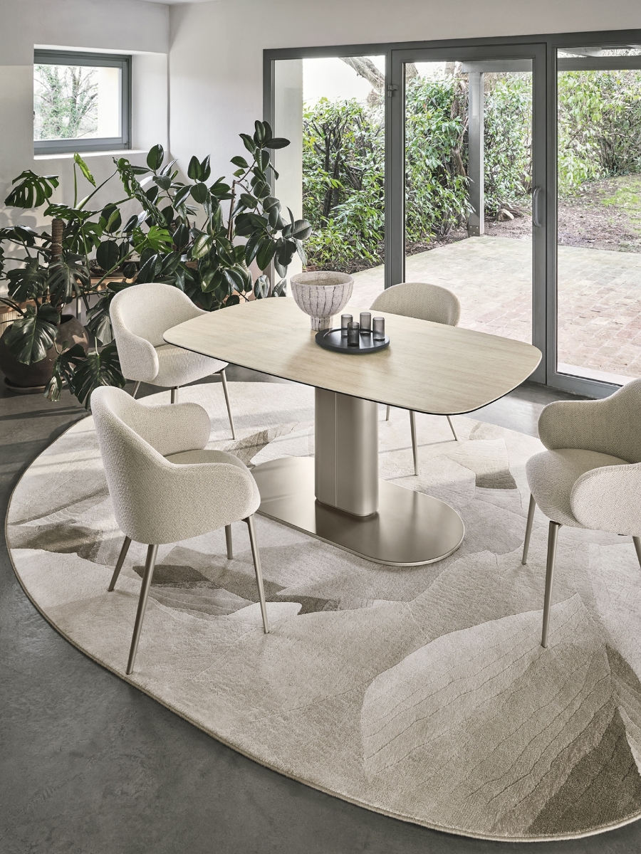 Χαλί οβάλ Calligaris Nest με οργανικό μοτίβο σε μπεζ taupe κάτω από τραπέζι με καρέκλες σε φωτεινή τραπεζαρία με μεγάλα παράθυρα — Adamopoulos Casa Ideale