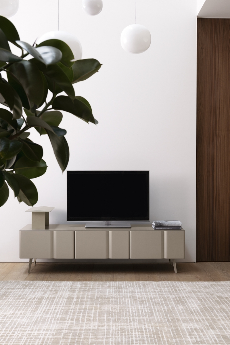 Έπιπλο τηλεόρασης Calligaris Bambu σε μπεζ-tortora απόχρωση με τηλεόραση από πάνω, σε μοντέρνο σαλόνι με ξύλινο πάτωμα, χαλί, φυτό και λευκά κρεμαστά φωτιστικά μπάλες
