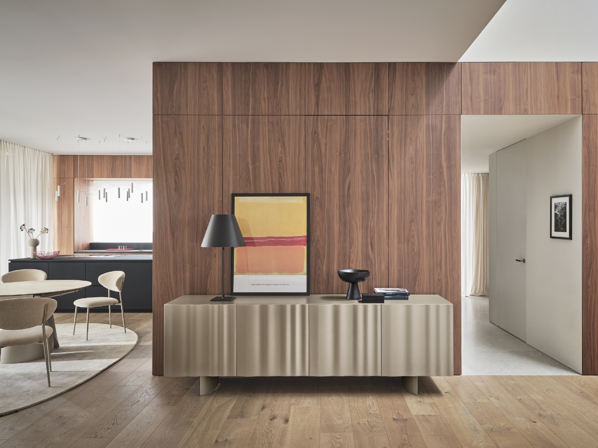 Μπουφές Calligaris Velo σε σαμπανί απόχρωση με ανάγλυφες πόρτες-πέπλο, σε ανοιχτό χώρο τραπεζαρίας με τοίχο καρυδιάς, μπεζ καρέκλες και στρογγυλό τραπέζι — Adamopoulos Casa Ideale, επίσημος αντιπρόσωπος Calligaris στην Ελλάδα